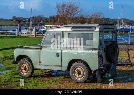 un vecchio difensore land rover o serie parcheggiata in un cantiere navale sull'isola di wight utilizzato per trainare e lanciare piccole barche nel fiume yar. Foto Stock