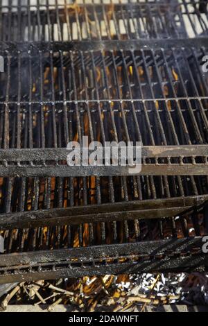 Fuoco su metallo griglia, barbecue e cucina fuori Foto Stock