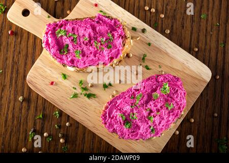 Formaggio di capra mescolato con barbabietola spalmata su pane - vista dall'alto Foto Stock