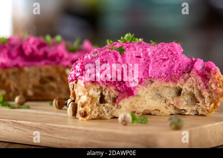 Formaggio di capra mescolato con barbabietola spalmata su pane - vista ravvicinata Foto Stock