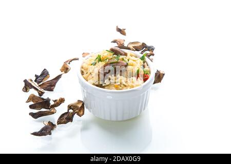 riso cotto con funghi secchi di bosco isolati su bianco Foto Stock