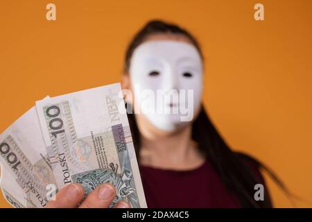 Note cartacee tenute in mano. Un giovane adulto tiene in mano i contanti con le dita. Mani tese davanti a me. Trecce africane. Foto Stock