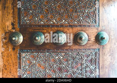 Modello islamico sulla parete di legno della moschea musulmana. Scultura in legno islamico con tradizionale motivo musulmano sulle porte e sulle pareti della moschea Foto Stock