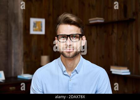 Giovane uomo d'affari sicuro che guarda la macchina fotografica, ritratto dell'headshot. Foto Stock