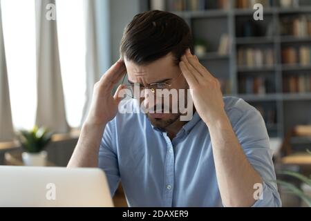 Il dipendente dell'ufficio soffre di gravi mal di testa i templi riducono il dolore Foto Stock