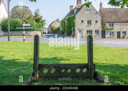 Antichi stock di legno su Village Green, Islip, Oxfordshire, Inghilterra, Regno Unito Foto Stock