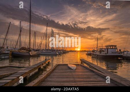 Molo con surf al porto olandese con barche a vela a. tramonto Foto Stock