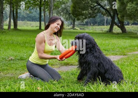 Giovane donna sorridente gioca con la barba nera durante la passeggiata nel parco. Foto Stock