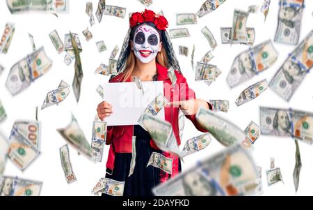 Donna che indossa giorno del costume morto tenendo vuoto vuoto banner sorridente che punta con mano e dito Foto Stock