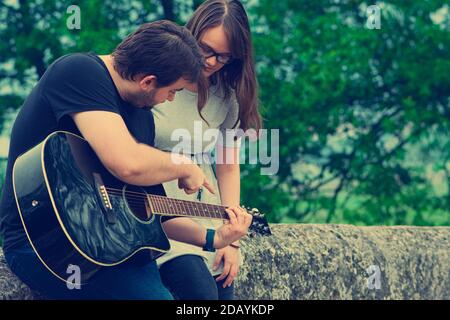 Fratello insegnava a suonare la chitarra in natura Foto Stock