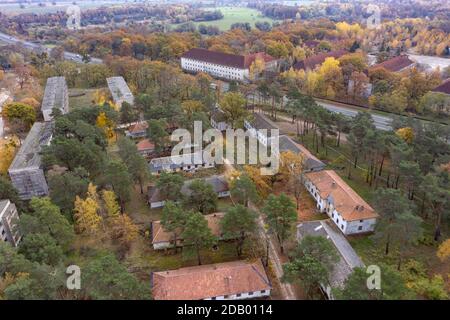 Elstal, Germania. 12 Nov 2020. Vista sulle rovine dell'ex villaggio olimpico di Elstal, nel Brandeburgo. Dopo decenni di negligenza con il conseguente decadimento degli edifici storici, i lavoratori edili determinano gli eventi in una parte della zona. Hanno rinnovato estesamente l'ex Sala da pranzo delle Nazioni nel Villaggio Olimpico e costruito ulteriori nuovi edifici residenziali nelle immediate vicinanze. Credit: Paul Zinken/dpa-Zentralbild/ZB/dpa/Alamy Live News Foto Stock