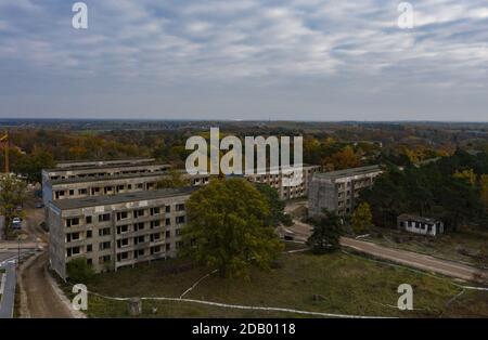 Elstal, Germania. 12 Nov 2020. Vista sulle rovine dell'ex villaggio olimpico di Elstal, nel Brandeburgo. Dopo decenni di negligenza con il conseguente decadimento degli edifici storici, i lavoratori edili determinano gli eventi in una parte della zona. Hanno rinnovato estesamente l'ex Sala da pranzo delle Nazioni nel Villaggio Olimpico e costruito ulteriori nuovi edifici residenziali nelle immediate vicinanze. Credit: Paul Zinken/dpa-Zentralbild/ZB/dpa/Alamy Live News Foto Stock