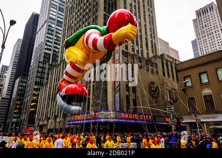 Il pallone Ronald McDonald galleggia in aria durante il Macy's. Parata del giorno del Ringraziamento lungo Avenue of Americas con radio Music Hall sullo sfondo Foto Stock