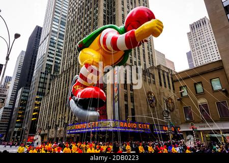 Il pallone Ronald McDonald galleggia in aria durante il Macy's. Parata del giorno del Ringraziamento lungo Avenue of Americas con radio Music Hall sullo sfondo Foto Stock