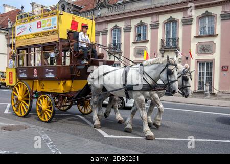 Un allenatore di palcoscenico è trainato da due cavalli lungo una strada nella parte della città vecchia di Varsavia, in Polonia. Foto Stock