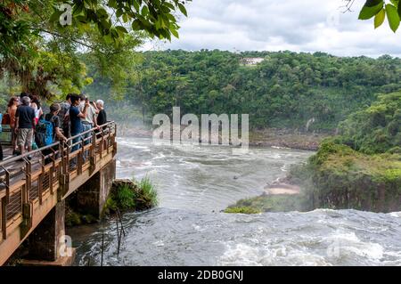 I visitatori su una piattaforma panoramica che si affaccia sulle Cascate Bossetti, parte delle Cascate di Iguazu nel Parco Nazionale di Iguazu sul lato argentino Foto Stock