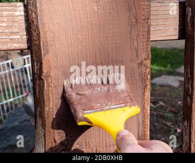 Dipingere una recinzione nel giardino Foto Stock