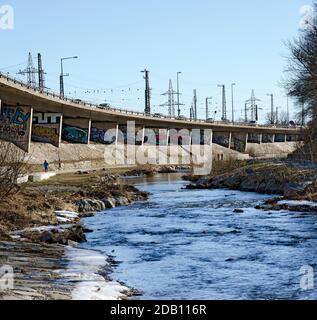 Strada pedonale sul letto del fiume viennese e strada sopraelevata con graffiti a Auhof, ingresso occidentale a Vienna, Austria Foto Stock