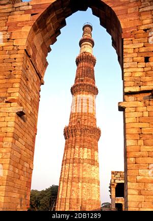 Vista del minareto Qutub Minar visto attraverso un arco, è il minareto in muratura di macerie più alto del mondo, Delhi, Delhi Union Territory, India. Foto Stock