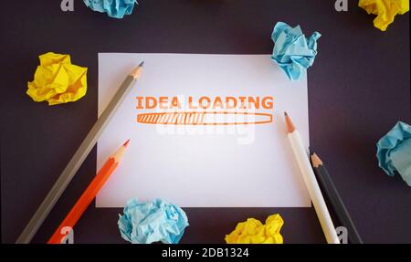 Scrittura testo idea Caricamento. Concetto che significa pubblicità il prossimo anno previsione dell'evento futuro. Matite e lobi di carta su sfondo scuro Foto Stock