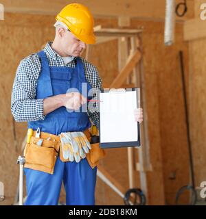 Lavoratore che mostra il documento nell'area del cantiere, spazio vuoto per la copia del testo Foto Stock