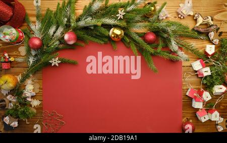 Sfondo rosso di Natale con decorazioni in legno e giocattoli. Spazio libero per il testo. Celebrazione e design decorativo. Foto Stock