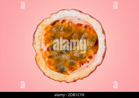 Maracuja tagliato a metà e intero con foglia su sfondo rosso. Frutto della passione giallo con succo di frutta e semi Foto Stock