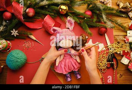 Creare bambola regalo di Natale per i bambini. Vista in primo piano di una bambola realizzata a mano con accessori Foto Stock