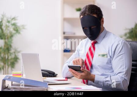 Dipendente con maschera in concetto di ipocrisia Foto Stock