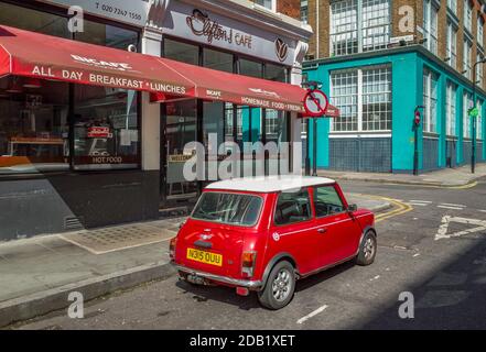Vintage Mini parcheggiato fuori da un Clifton's Cafe nel quartiere di Shoreditch a Londra. Red and White Classic Mini Cooper 1.3i Londra. Foto Stock