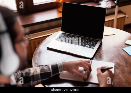 Studente al portatile con schermo vuoto apprendimento online indoor, Mockup Foto Stock