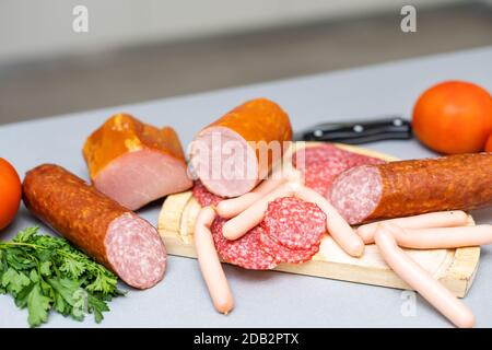 composizione di tagli a freddo su tavola di legno di tipo diverso di formaggio Foto Stock