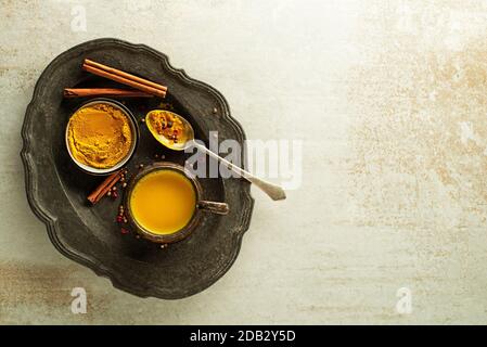 Bibita salutare realizzato da radici di curcuma, spezie, il latte e il miele. Golden latte, fatta con la curcuma e altre spezie Foto Stock