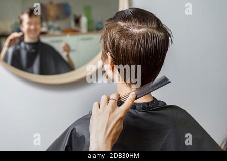 parrucchiere pettinatura capelli bagnati del cliente. salone di bellezza Foto Stock