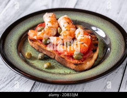 Bruschetta italiana con gamberi e capperi sul piatto Foto Stock