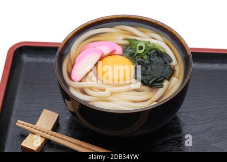 Spaghetti Kamaage udon giapponesi in un recipiente in ceramica con bacchette sul vassoio Foto Stock