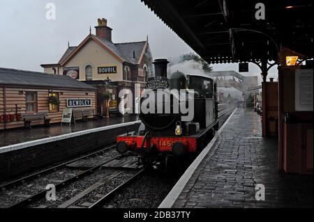 GWR Tank loco 1450 passa attraverso la stazione di Bewdley in una giornata di vento umido presso la Severn Valley Railway, Worcestershire, Regno Unito Foto Stock