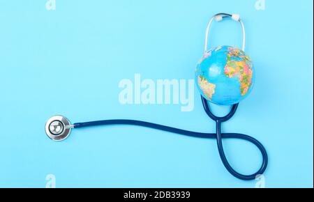 World Health Day Concept, Stethoscope, globo su sfondo blu con spazio di copia. Assistenza sanitaria globale Foto Stock