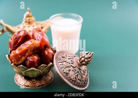 Ramadan, Date in ciotola d'oro, Latte, arabian Aladdin stile vintage lampada d'oro su sfondo verde nero Foto Stock