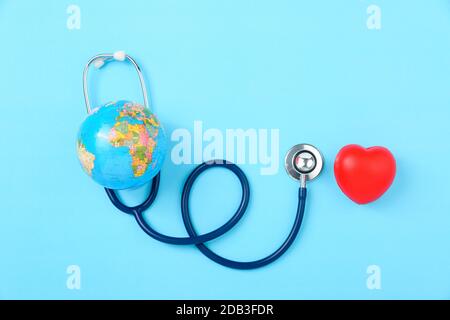 World Health Day Concept, Stethoscope, globo e cuore rosso su sfondo blu con spazio copia. Assistenza sanitaria globale Foto Stock