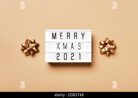 Lightbox con testo ALLEGRO XMAS 2021 e decorazione dorata di natale su sfondo beige. Layout creativo in colori monocromatici neutri Foto Stock