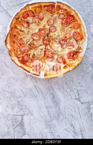 Pizza fatta in casa su un piatto bianco su sfondo bianco con un posto per il testo. Spazio di copia. Messa a fuoco morbida Foto Stock