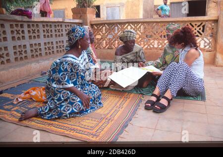 I membri di una comunità Women's Group parlano con un assistente del loro programma di sensibilizzazione contro l'HIV/AIDS per le donne locali. Sevare, Mali Foto Stock