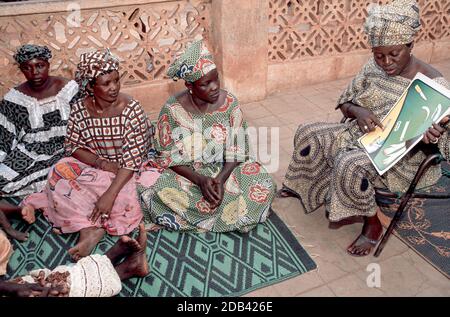 Un educatore di comunità di un gruppo femminile locale che insegna la consapevolezza dell'HIV/AIDS con schede da immagine per le donne locali. Sevare, Mali Foto Stock