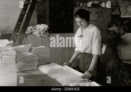 Asciugamani pieghevoli ragazza di 15 anni in Bonanno lavanderia.] Location: [Boston, Massachusetts. Foto Stock