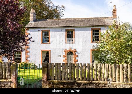 Il Croft, una casa tradizionale del tardo 18 ° secolo con quine di arenaria rossa rialzata e medicazioni nel villaggio di Irthington, Cumbria UK
