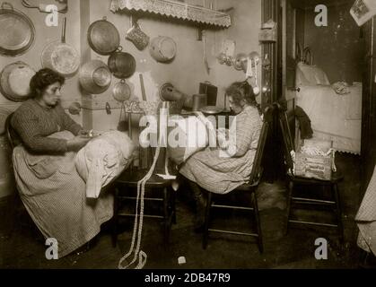 La sig.ra Palontona e la figlia di 13 anni, Michaeline, lavorando su 'Pillow-merletto' in cucina sporca della loro casa di locazione, 213 E. 111th Street, 3 ° piano. Erano entrambi molto analfabeti. Madre sta facendo il pizzo fantasia e la ragazza mi ha venduto il pezzo su cui ha lavorato. Foto Stock