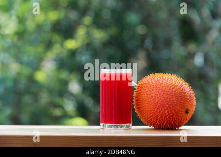 Baby Jackfruit, frutta GAC con succo di jackfruit su sfondo sfocato. Bevanda e concetto sano. Foto Stock