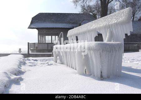 Das Vom Wind ans Ufer gepeitschte Wasser ließ Bänke, Einstiege und Geländer am Ufer des Attersees vereisen. - l'acqua schiacciata dal vento ha fatto le banche, Foto Stock