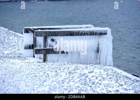 Das Vom Wind ans Ufer gepeitschte Wasser ließ Bänke, Einstiege und Geländer am Ufer des Attersees vereisen. - l'acqua schiacciata dal vento ha fatto le banche, Foto Stock